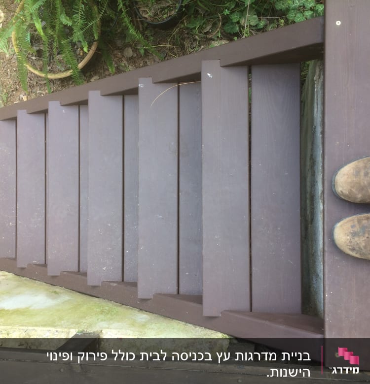 מדרגות עץ חומות עם נעליים חומות על מדרגה עליונה